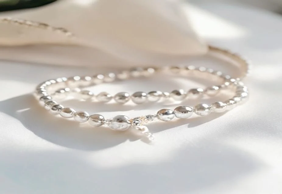 A beaded elastic charm bracelet being wiped with a soft cloth