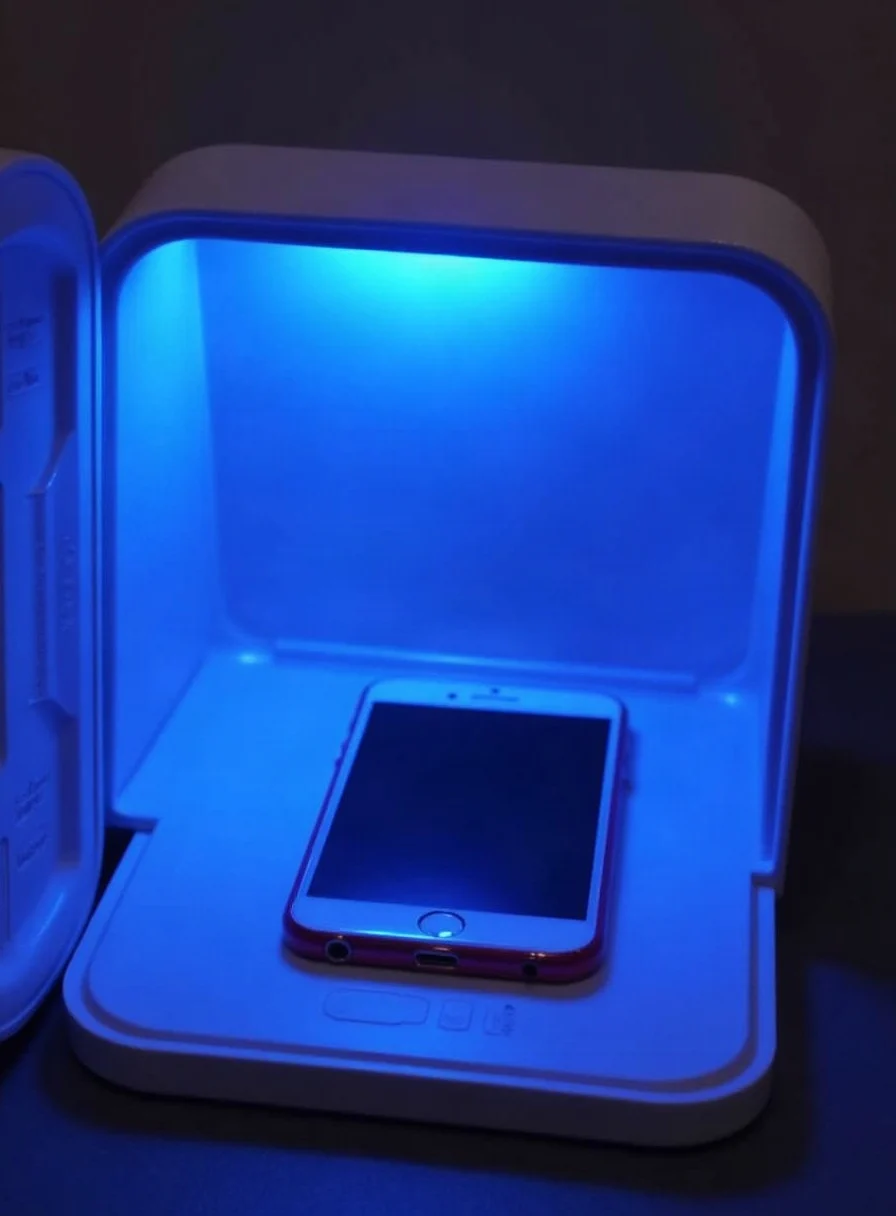 A phone being sanitised inside a UV-C box